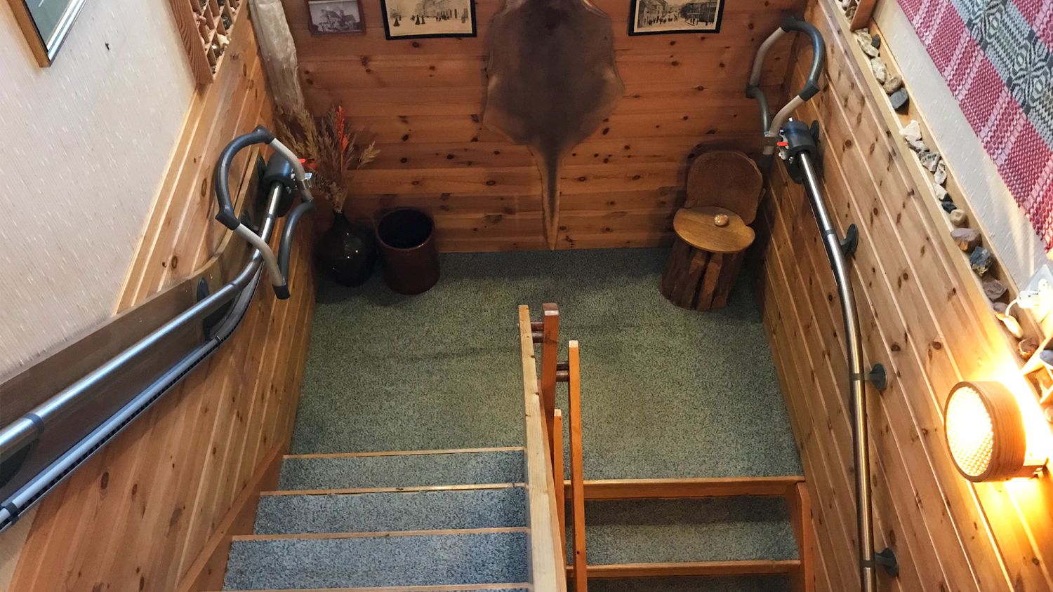 Treppensteighilfe AssiStep mit Treppenhandlauf aus Edelstahl an einer Kurventreppe mit Podest montiert